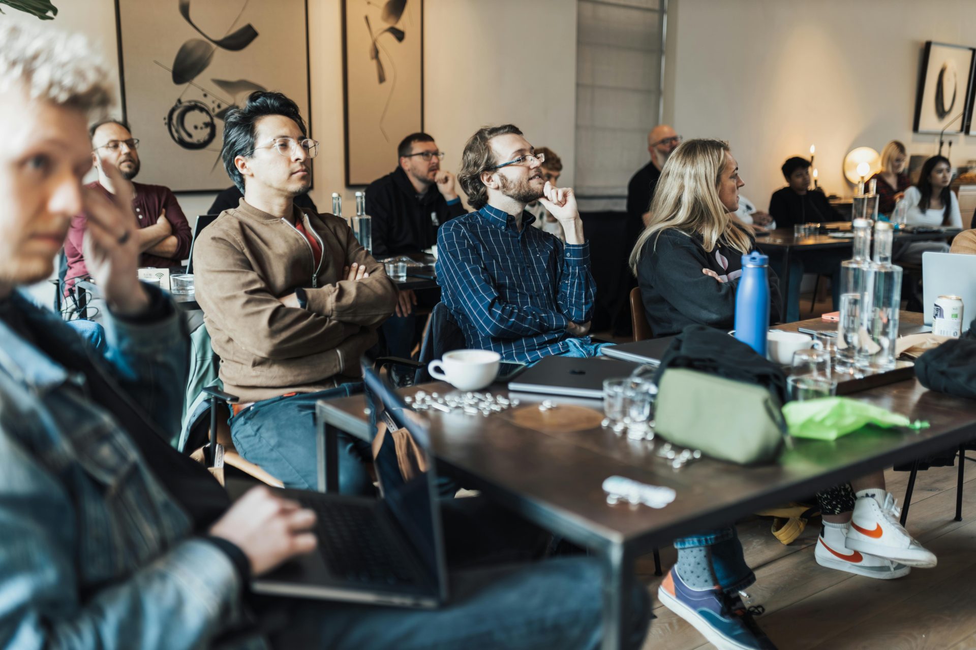 Diverse group of adults attending an educational seminar, focused on a presentation inside a modern conference room.
